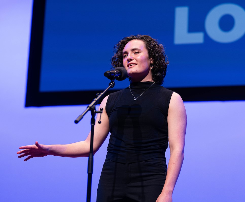A student recites on stage.